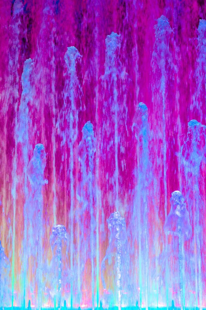Eine abstrakte Grafik von einem Wasserspiel vermutlich eines Springbrunnens in Blau und Violett
