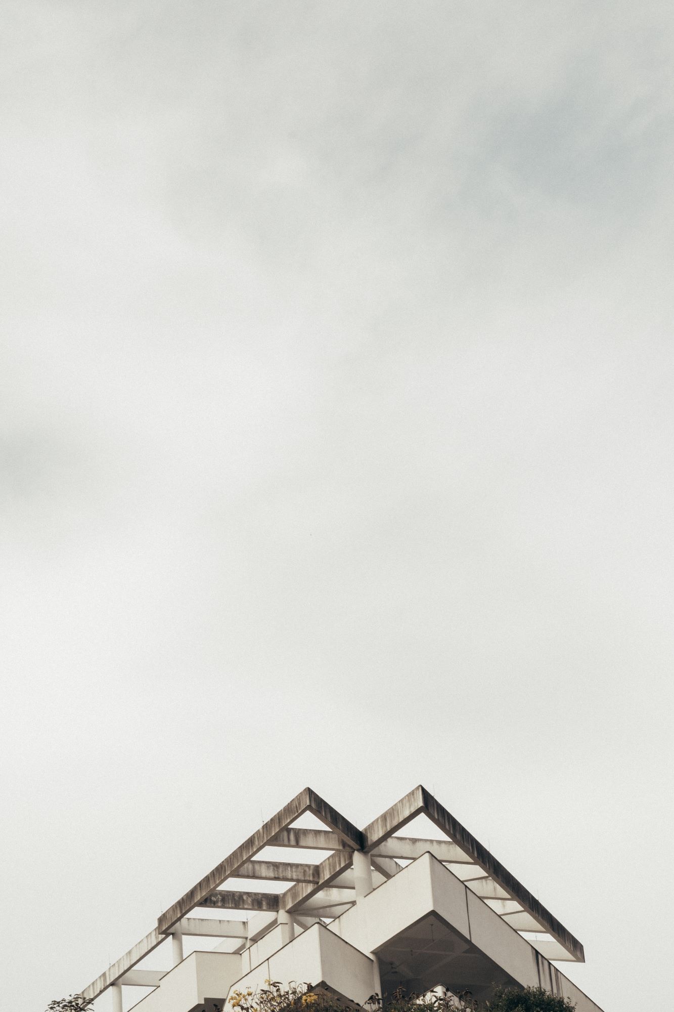 Gräuliches Bild das vor allem Himmel zeigt aber im Anschnitt auch das sehr spitze dreieckige Dach eines Hauses