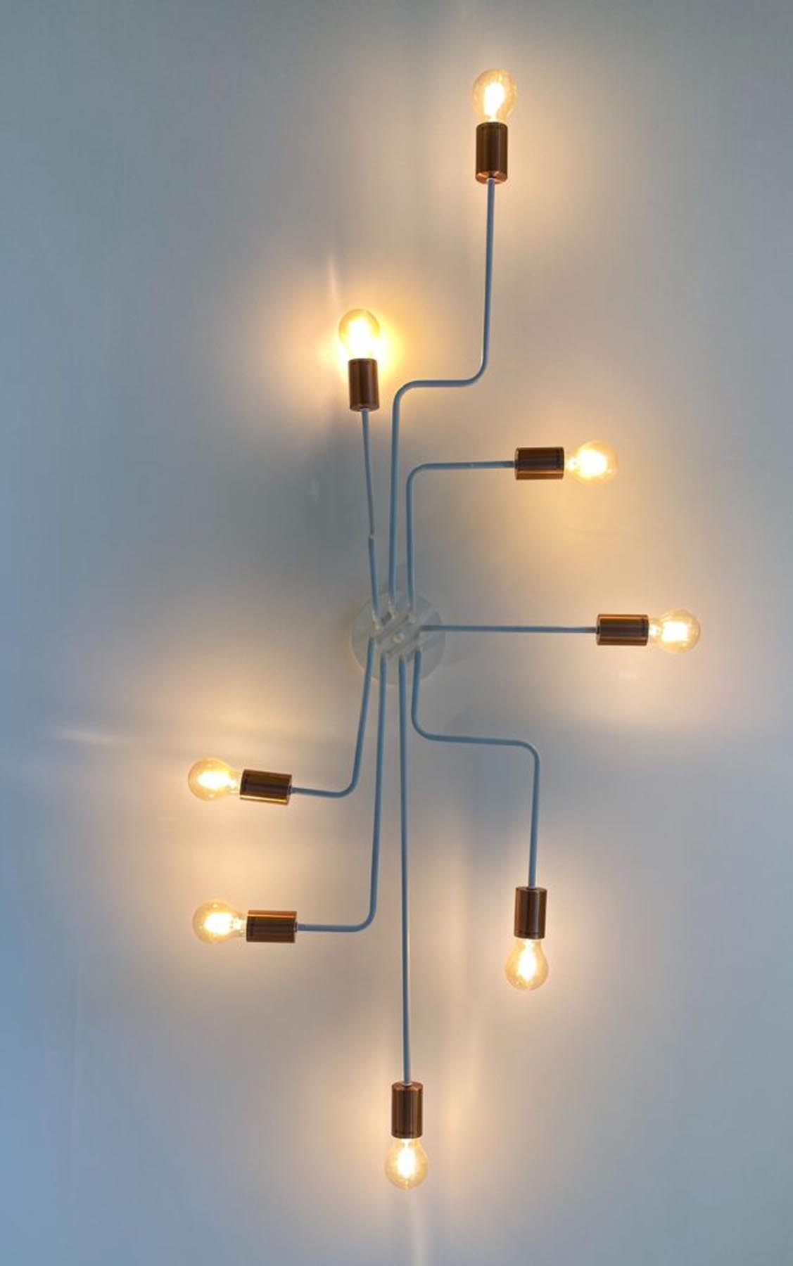 Eine moderne Leuchte führt in verschiedene Richtungen geschwungene Glühbirnen