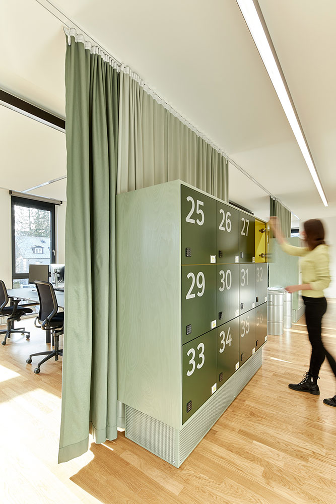 Schliessfächer in grünem Farbdesign auf offener Bürofläche bei AutoScout24