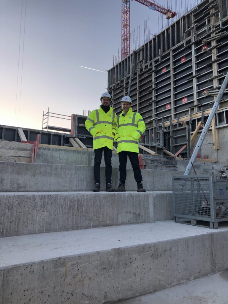 Zwei Personen die auf Stufen bei der Baustelle bei ALDI Nord stehen