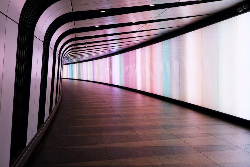 Menschenleerer Gang mit futuristisch beleuchteten Wandpaneelen