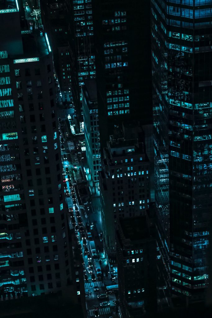 Blick von oben auf Großstadt bei Nacht mit Licht durch Autos und Büros