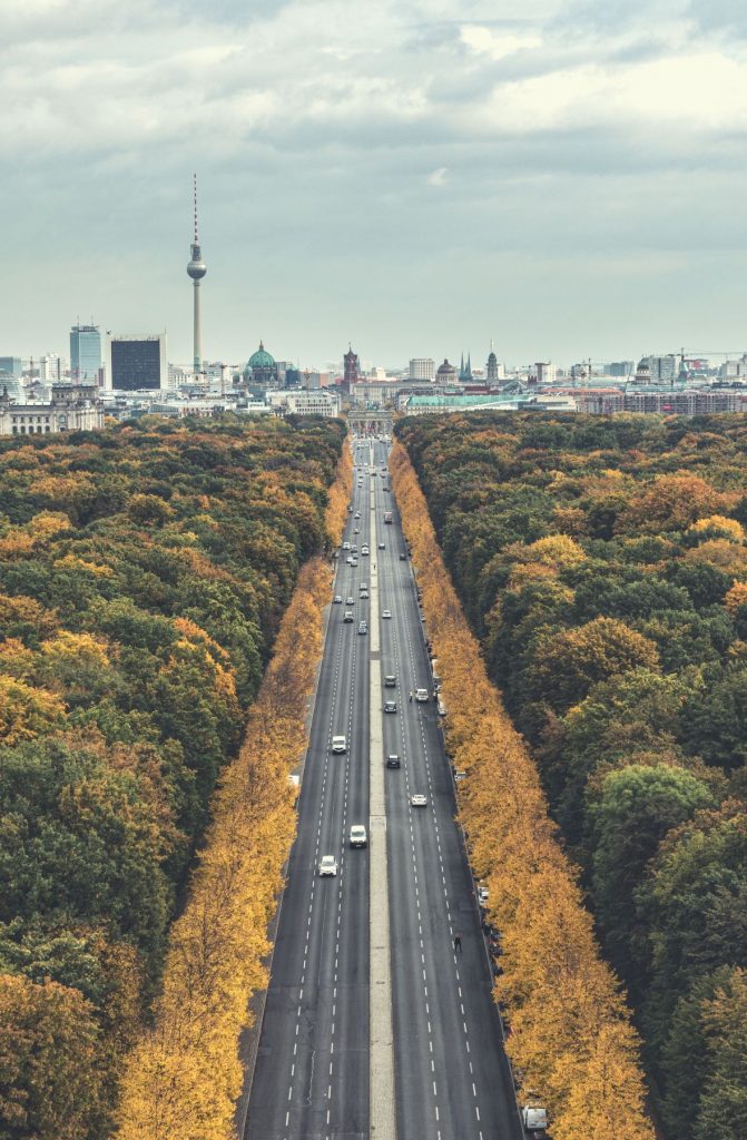 Blick von oben auf die Straße des 17. Juni auf der großen Ost-West-Achse Berlins mit dichtem Herbstbaumbestand Brandenburger Tor und Telespargel