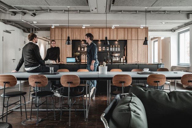 Menschen kommen in einem kreativen Workspace mit Kaffeebar bei combine Düsseldorf zusammen