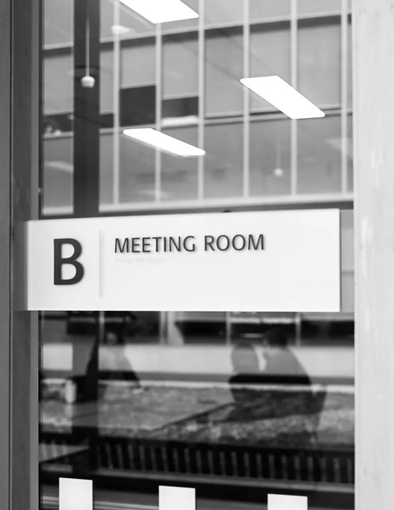 Schwarzweiß Foto eines Raums mit dem Schild Meeting Room