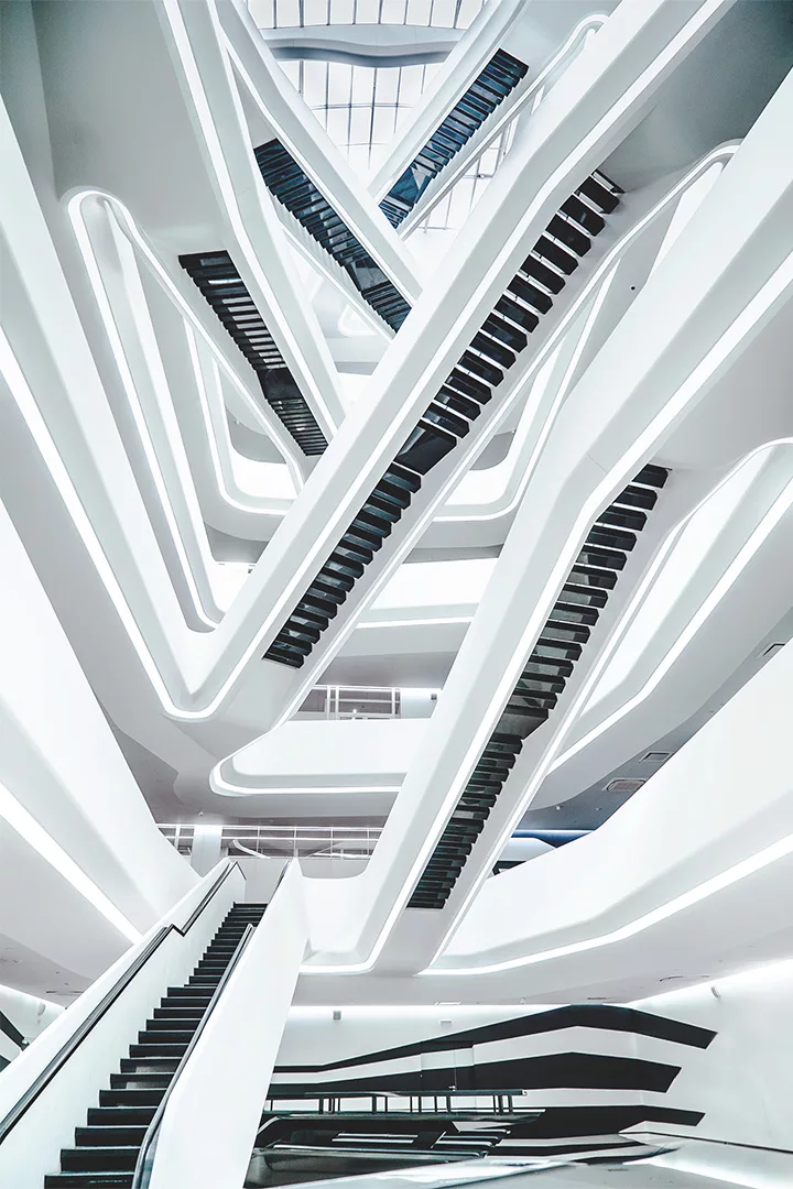 Ein weißes modernes Bürogebäude mit überkreuzten Rolltreppen zischen den Stockwerken