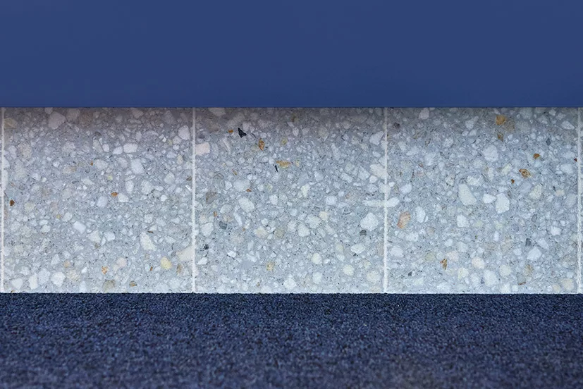 Detailfoto des Bürodesigns bei der ZBI mit blauem Teppich grauen Terrazzosteinen und blauer Wand
