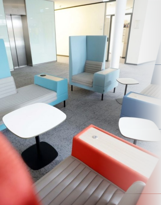 Eine Arbeitsfläche mit Sesseln und Beistelltischen in knallig-bunten Farben